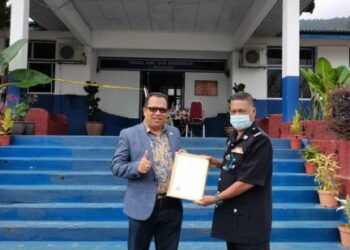 ZUHAIRI Ab. Kadir (kiri) menyampaikan surat penghargaan kepada Maznan Omar di Balai Polis Bukit Tinggi di Bentong, Pahang.