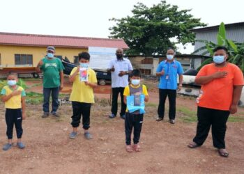 EMPAT orang adik beradik yang terpaksa berkongsi telefon bimbit bagi mengikuti PdPR menerima bantuan peranti daripada Pusat Khidmat Rakyat Port Dickson dan pejabat ADUN Sri Tanjung yang diserahkan oleh Pegawai Pusat Khidmat Ahli Parlimen Port Dickson, Mejar (B) Hasrin Abdul Samat (dua, dari kanan).-UTUSAN/MOHD. SHAHJEHAN MAAMIN.