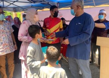 NOH Omar ( kanan) menyerahkan sumbangan kepada salah seorang penerima dalam majlis Penyampaian Sumbangan kepada Anak Yatim dan Ibu Tunggal Parlimen Tanjong Karang, Selangor hari ini.