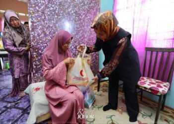 RAJA Zarith Sofiah Sultan Idris Shah (kanan) ketika melawat keluarga terjejas akibat pandemik Covid-19 di Mukim Endau, Mersing di Johor.