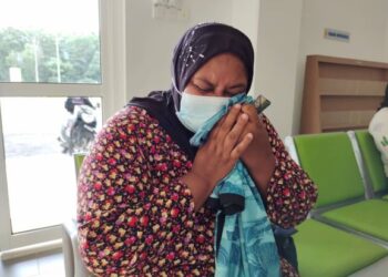 SHAHIDA mencium baju  arwah anaknya, Muhammad Ikhmal Zaqwan Khan yang meninggal dunia dalam kemalangan tiga buah motosikal di Rembau, malam kelmarin.– UTUSAN/NOR AINNA HAMZAH.