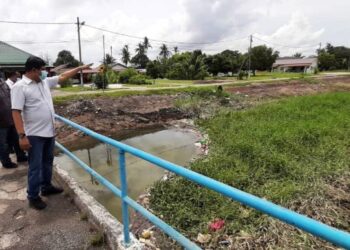 MOHAMAD ALI Mohamad menunjukkan Sungai Ayer Salak  yang dipenuhi semak samun dan pohon kiambang di Kampung Bukit Datuk A, Bukit Rambai, Melaka. - UTUSAN/AMRAN MULUP