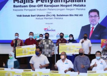 SULAIMAN Md. Ali (tengah) bergambar bersama penerima bantuan pada majlis penyampaian bantuan one-off kerajaan negeri Melaka kepada penggiat industri pelancongan di Hotel MITC, Ayer Keroh, Melaka. - UTUSAN/RASUL AZLI SAMAD