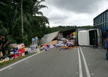 KIRA-KIRA 200 kotak buah-buahan bertaburan di jalan raya selepas sebuah lori terbalik di Jalan Seremban-Tampin dekat selekoh Kampung Lada, Rembau pagi tadi.-UTUSAN/NOR AINNA HAMZAH.
