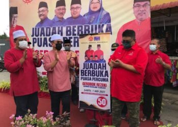 SULAIMAN Md. Ali (kiri) bersama Ab. Rauf Yusoh (kanan) ketika majlis mengedarkan bungkusan makanan percuma kepada pengunjung bazar Ramadan di Masjid Tanah, Melaka. - UTUSAN/MUHAMMAD SHAHIZAM TAZALI