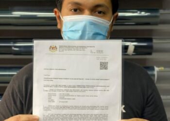 MOHD. Hafizee Mohd. Arop menunjukkan surat kebenaran beroperasi bagi pengusaha kedai aksesori filem penapis haba atau tinted kenderaan semasa PKP yang dikeluarkan oleh MITI di Ipoh hari ini. - UTUSAN/ASLIZA MUSA