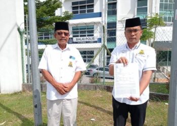 HAIROL Nazli Hamdan (kanan) menunjukkan laporan polis dibuat ke atas pemilik akaun Facebook, Faruq Sungib di IPD Johor Bahru Selatan, Johor.