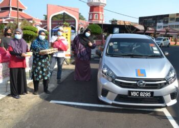 AZLIN Ali (lima dari kiri) menyampaikan sumbangan kepada tenaga pengajar institut memandu yang terkesan daripada pendapatan akibat PKP di Pusat Gelandangan Dapur Kausar dekat Jalan Tam Yeong, Seremban. - UTUSAN/ZAKKINA WATI AHMAD TARMIZI