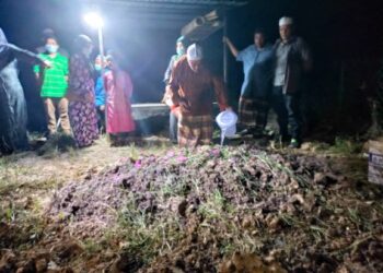 AHLI keluarga menyiram air dan bunga ke atas pusara Nor Hayati di Tanah Perkuburan Islam Kampung Lubuk Pusing, Bagan Terap, Sungai Besar, Selangor, malam tadi. -Foto ISKANDAR SHAH MOHAMED