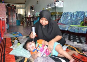 HARYANTI Hamzah bersama Naura Qalesya yang menghidap kecacatan kromosum sejak dilahirkan di rumahnya di Taman Pemarak, Tanjung Ipoh, Kuala Pilah. –UTUSAN/ZAKKINA WATI AHMAD TARMIZI