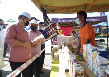 SULAIMAN Md. Ali (kiri) dan Ahmad Hamzah (tengah) melihat produk jualan peniaga pada program tinjauan Jualan Myrakyat di Masjid Tanah, Melaka. - UTUSAN/MUHAMMAD SHAHIZAM TAZALI