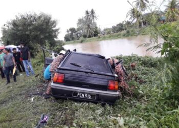 ANGGOTA bomba membantu mengeluarkan mayat pemandu kereta yang dihempap sebatang pokok yang tumbang  di Jalan Sungai Korok, Jitra, Kubang Pasu, hari ini.