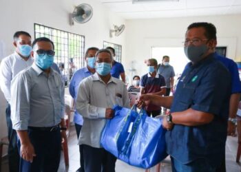 ABDUL Rahman Mohamad (kanan) menyerahkan set bakul makanan kepada masyarakat Orang Asli di Kampung Chang, Sungai Gepai, Bidor hari ini. - UTUSAN/ZULFACHRI ZULKIFLI