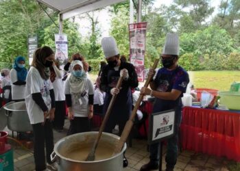 ONN Hafiz (dua kanan) menyediakan bubur lambuk dalam program Bubur Lambuk Southern Volunteers, di Johor Bahru, Johor. -UTUSAN/KHAIRUL MOHD ALI