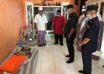 SIK Choon Foo (dua, kanan) menziarahi anak pesara polis, Zakaria Ibrahim yang terlantar sakit barah otak di rumahnya di Bandar Utama, Gua Musang, Kelantan, hari ini. - UTUSAN/AIMUNI TUAN LAH