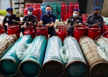 MOHD. Ridzuan Ab. Ghapar (tengah) menunjukkan hos gas yang digunakan untuk memindahkan gas daripada tong LPG bersubsidi kepada tong gas LPG industri dalam satu serbuan di Jalan Kampung Telok, Nibong Tebal, Pulau Pinang hari ini.