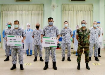 MUHAMMAD Ridzwan Abdul Rahman (tengah) bersama pegawai dan petugas HATL selepas menerima suntikan vaksin Covid-19 di Pangkalan TLDM Lumut hari ini. - UTUSAN