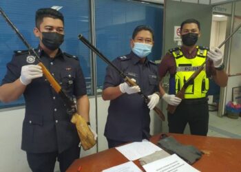 BAHARUDIN Abdullah (tengah) menunjukkan senapang tiruan yang dirampas di Felda Kertih 5 dan 6 di Ketengah Jaya, Dungun, hari ini.- UTUSAN/NIK NUR IZZATUL HAZWANI NIK ADNAN