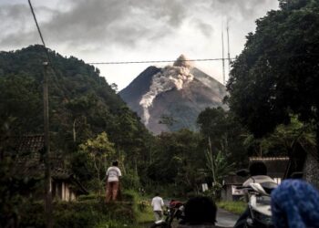 PENDUDUK tempatan melihat Gunung Merapi yang mengeluarkan debu panas di Yogyakarta, Indonesia. - AFP