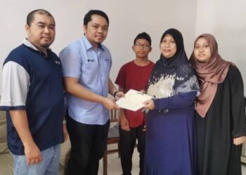 KHAIRUL Na’im (dua dari kiri) dan Pengurus Jabatan Komunikasi Korporat YBR, Mohamad Ghazali Zainal Abidin menyerahkan lebihan pampasan takaful PPBU kepada Siti Norzah di kediaman arwah di Taman Impian Emas, Skudai, Johor.