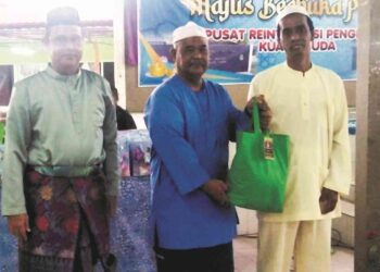 ABDUL Kadir Jailani Ismail (tengah) menyampai sembangan kepada seorang penduduk, Adnan Ahmad sempena Majlis Berbuka Puasa Bersama Orang Di Selia (ODS) Serta Komuniti 2023 di Pusat Reintegrasi Penghuni (PRP) Kuala Muda, Sungai Petani, Kedah baru-baru ini. 
– UTUSAN/Abd Razak Osman