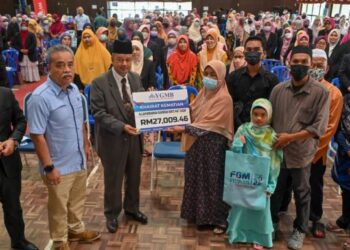 TUN Mohd. Salim Tun Ibrahim (tiga dari kiri) menyampaikan khairat kematian YGMB kepada Tuan Kamariah Raja Yusof sambil diperhatikan Ketua Pegawai Eksekutif YGMB,Datuk Wan Munadi Wan Mamat (kiri) di Kuala Nerus, Terengganu hari ini. - UTUSAN/PUQTRA HAIRRY ROSLI