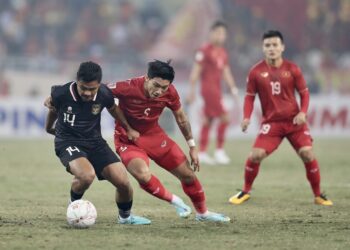 Pemain Indonesia, Asnawi Mangku Alam (jersi hitam) cuba melepasi kawalan pemain Vietnam, Doan Van Hau (jersi merah)  dalam aksi separuh akhir kedua Piala AFF di Stadium My Dinh, Hanoi sebentar tadi. (Foto: VNexpress)