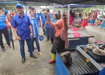 TENGKU Zafrul Tengku Abdul Aziz beramah mesra dengan peniaga pada program lawatan itu di Pantai Remis, Kuala Selangor, Selangor. -UTUSAN/ ISKANDAR SHAH MOHAMED