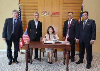 Chaterine Tai (duduk) menandatangani buku tetamu ketika mengadakan kunjungan hormat ke atas Tengku Zafrul Abdul Aziz semalam.