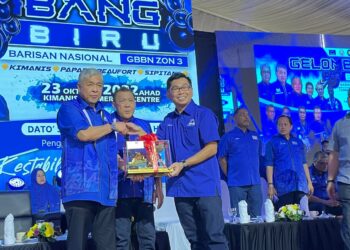 AHMAD Zahid Hamidi (kiri) menerima cenderamata daripada Ketua BN Kimanis, Datuk Mohamad Alamin (kanan) sambil disaksikan oleh Pengerusi BN Sabah, Datuk Seri Bung Moktar Radin dalam Program Gelombang Biru di Kimanis, Sabah, hari ini.
