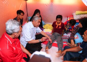 AHMAD Zahid Hamidi (kiri) beramah mesra bersama mangsa banjir di PPS Sekolah Kebangsaan Sungai Tiang Darat di Bagan Datuk hari ini. - UTUSAN/ZULFACHRI ZULKIFLI