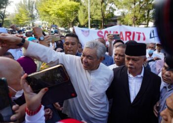 AHMAD Zahid Hamidi yang tiba di Mahkamah Tinggi Shah Alam menyapa kira-kira 100 penyokongnya sebelum memasuki bilik mahkamah bagi mendengar keputusan sama ada dibebaskan atau dipanggil membela diri di atas 40 pertuduhan menerima rasuah berkaitan Sistem Visa Luar Negara (VLN). - UTUSAN/SHIDDIEQIIN ZON