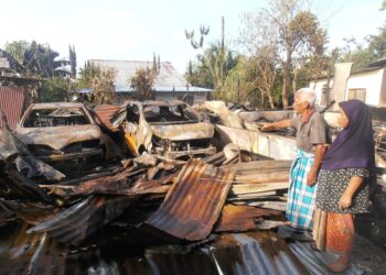 MUSTAFFA Ahmad dan Che Wan Ramli melihat kesan kebakaran rumah mereka di Kampung Kongsi Enam, Bedong, Sungai Petani, semalam.