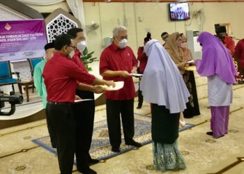 TENGKU Mohamad Rizam Tengku Abdul Aziz menyampaikan bantuan wang tunai kepada penerima dalam Majlis Pengurniaan Sumbangan Zakat dan Fidyah di Masjid Muhammadi Kota Bharu, Kelantan, hari ini. - UTUSAN/ROSLIZA MOHAMED
