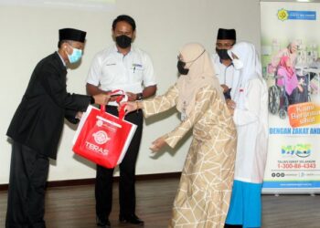 ANHAR Opir (kiri) bersama Mohd. Sabirin Mohd. Sarbini (dua kiri) ketika menyampaikan sumbangan bantuan pendidikan kepada penerima pada Program Pelancaran Bantuan Pendidikan Sesi Persekolahan Tahun 2022 Negeri Selangor di UKM, Bangi Selangor. - UTUSAN/FAISOL MUSTAFA