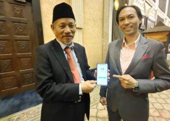 SHAIKH Harun Shaikh Ismail (kiri) menunjukkan sistem e-Amil yang diperkenalkan untuk bayaran zakat selepas majlis Multaqa Amil Zakat Negeri Terengganu 2023 di Kuala Terengganu, hari ini.