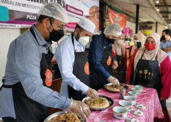 NIK Muhammad Zawawi Salleh (dua dari kiri) cuba menghasilkan piza sendiri dalam program Jelajah Agropreneur Muda di Pasir Tumboh, Kota Bharu, Kelantan hari ini. - UTUSAN/ROSALWANI CHE SOH