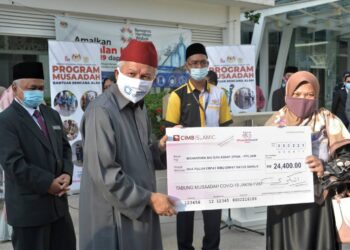 ZULKIFLI Mohamad Al-Bakri menyerahkan sumbangan kepada Rosmawati Mohamad Rasit di Kompleks Islam Putrajaya hari ini. - UTUSAN/FAISOL MUSTAFA